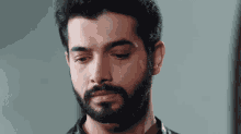 a man with a beard has a tear running down his face