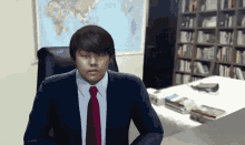 a man in a suit and tie sitting at a desk