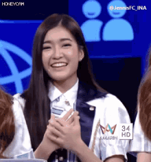 a girl with long hair is smiling and wearing a shirt with the number 34 on it