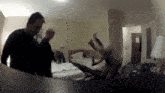 a group of people are standing in a hotel room with two beds
