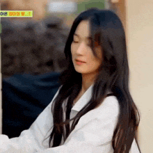 a young woman with long black hair is wearing a white shirt and a black tie .