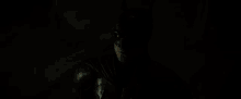 a close up of a man wearing a batman costume in the dark .