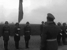 a black and white photo of soldiers marching in a line