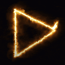 a triangle that is on fire with a dark background