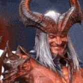a demon with horns is smiling and holding a pumpkin .