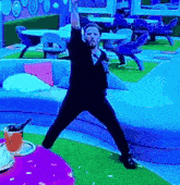 a man with a beard is dancing in a room with tables and chairs .