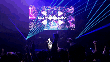 a crowd of people watching a dj named out my perform