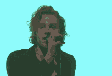 a man is singing into a microphone while wearing a black shirt .