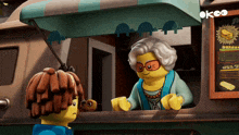 a lego character talking to an older woman in front of a sign that says okco