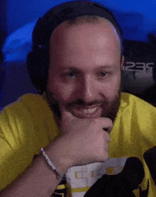 a bald man with a beard wearing headphones and a yellow shirt with the number 235