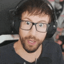 a man wearing glasses and headphones is making a surprised face