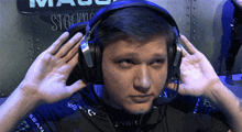 a man wearing headphones and a black shirt that says logitech on it
