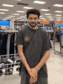 a man in a gray shirt with a sun on it
