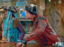 a man and a woman are sitting at a table in front of a sign that says " sea slug sandwich "