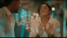 a man and a woman are having a conversation and the woman has glasses on