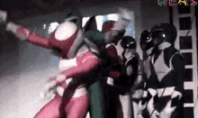 a group of power rangers are standing next to each other .