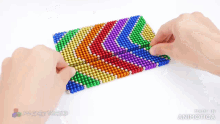 a person is playing with a bunch of colorful magnets made by magnetworld