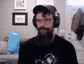 a man with a beard is wearing headphones and glasses
