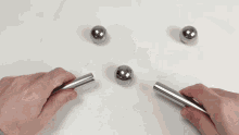 a person is holding a metal object that looks like a cross
