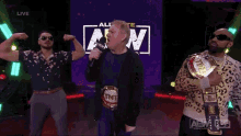 three men are standing in front of an aw logo