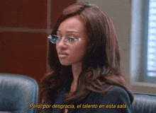 a woman wearing glasses says " pero por desgracia el talento en esta sala " in yellow letters