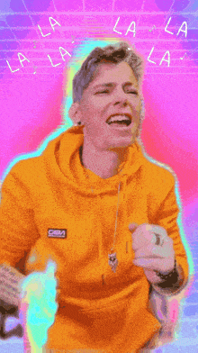 a man in a yellow hoodie is singing the song la la la