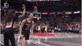 a female basketball player from the indiana team high fives her coach