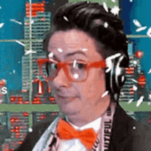 a man wearing headphones and a bow tie is looking at the camera .