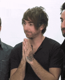 a man with a tattoo of a rose on his hand is praying
