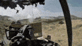 a military vehicle is driving through a desert with smoke coming out of the gun