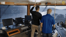 two men are looking out a window with breaking bobby bones written on the bottom