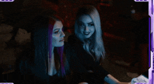two women sitting next to each other with purple hair