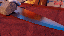 a cartoon character is holding a large rock and a knife with the words sausage party written in red