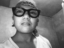 a black and white photo of a person wearing glasses