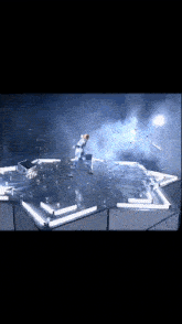 a person in a white suit is standing on a stage with a lot of lights on it