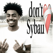 a young man giving the middle finger with the words " don 't sybau " behind him