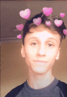 a young man with hearts on his head looks at the camera