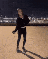 a woman in a black sweater and black pants is dancing