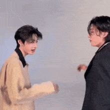 two young men are dancing together and one of them is wearing a shirt that says design .
