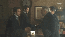 a group of men shaking hands in a room with hbo written on the bottom right