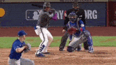 a baseball game is being played in front of a mets advertisement