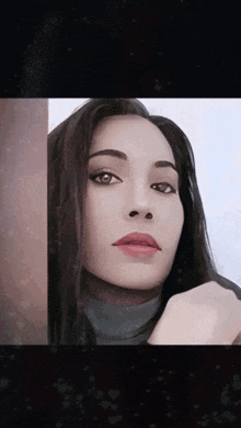 a close up of a woman 's face with her hand on her face