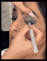 a woman is getting her makeup done by a makeup artist