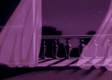 a balcony with purple curtains and a railing at night