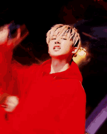 a man in a red jacket is holding a red object in his hand
