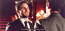 a man in a suit and tie is talking to another man in a room .