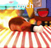a cartoon character is laying on a red and white striped table cloth with the word ouch written on it