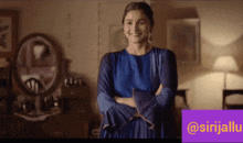 a woman in a blue dress is standing with her arms crossed in front of a mirror