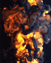 a close up of a fire with smoke coming out of it against a dark background