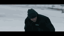 a man and a woman are walking through the snow